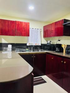 a kitchen with red cabinets and a sink at Nadi Holiday House in Nadi +6 photos