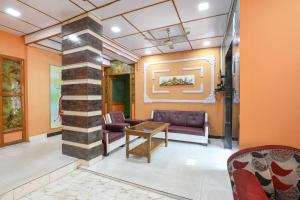 a lobby with a pillar with a couch and a table at SPOT ON Hotel River View in Guwahati