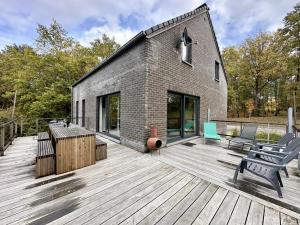 a brick house with a deck with a bench at The Green in Durbuy