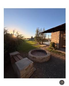 a fire pit with a bench next to a building at La tota casa de campo in Pocito +17 photos