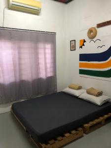 a bed in a room with a window at Surf house langkawi in Pulau Tepur