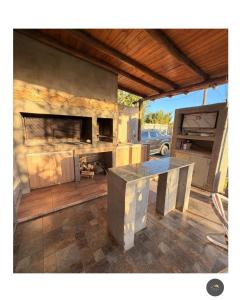 a outdoor kitchen with a table and a fireplace at La tota casa de campo in Pocito