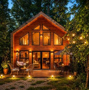 a log cabin with a table and chairs in the yard at Casa Rosa in Coñaripe