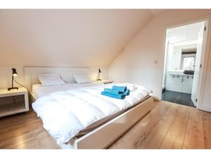 a large white bed with a blue towel on it at The Green in Durbuy
