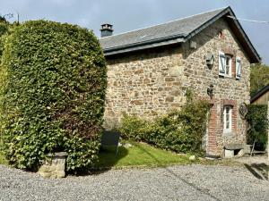 a brick building with a large bush next to it at Le Fournil in Manhay
