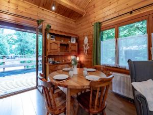 ein Esszimmer aus Holz mit Tisch und Stühlen in der Unterkunft lOrée in Biron