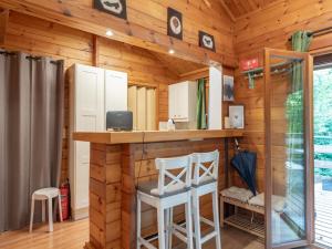 Eine Küche in einer Blockhütte mit einer Bar und zwei Hockern in der Unterkunft lOrée in Biron + 13 Fotos