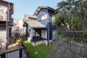 a blue house with a yard with green grass at Tsuga1976 in Chiba