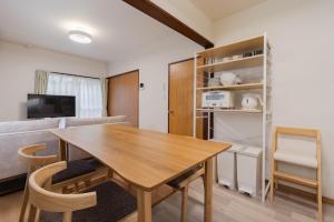 a kitchen and living room with a wooden table and chairs at Tsuga1976 in Chiba