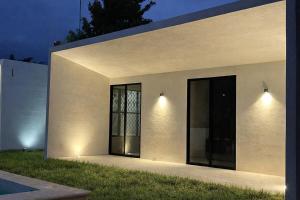 a white building with two large glass doors at Casa Nahox in Hunucmá +7 photos