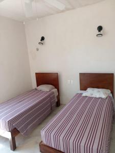 two beds in a white room with two beds sidx sidx sidx at Casa Nahox in Hunucmá