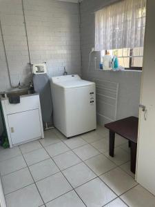 a small kitchen with a washing machine and a sink at Villa on Ferguson in Ipswich