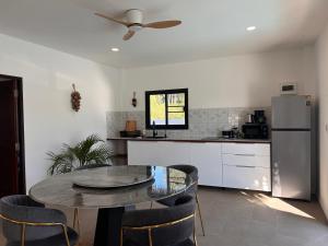 a kitchen with a table and a refrigerator at Villa L Aurora in Taling Ngam Beach