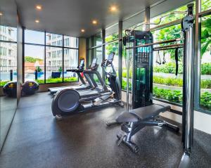 a gym with three treadmills and elliptical machines at Hotel Mi Rochor in Singapore