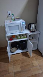 a white microwave oven sitting on top of a shelf at Apartamento Indaiatuba in Indaiatuba