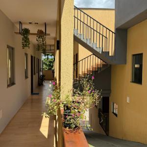 a hallway of a building with potted plants and stairs at VR VILLAGE - APT 02 - Studio completo próximo ao Shopping da Ilha in São Luís