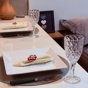 a table with two plates and wine glasses on it at VR VILLAGE - APT 02 - Studio completo próximo ao Shopping da Ilha in São Luís