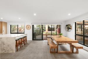 a kitchen and dining room with a wooden table and benches at The Beach House on Pembrey in Cowes