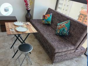 a couch with a table and a table with plates on it at Apartamento en el Rodadero, a pocos metros de la playa in Gaira
