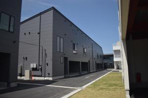 a large gray building with a street in front of it at Nord SUR in Ichinomiya
