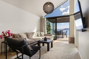 a living room with a couch and a table at Roam Taupo Lakefront Combined Units 3&4 in Taupo