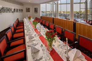 a long table in a room with red chairs at Hilton Mainz in Mainz