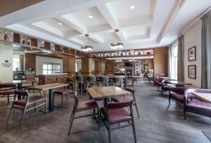 a restaurant with tables and chairs in a room at DoubleTree by Hilton Raleigh-Cary in Cary