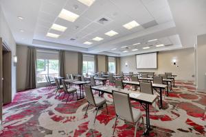 a conference room with tables and chairs and a screen at DoubleTree by Hilton Raleigh-Cary in Cary +58 photos