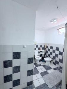 a bathroom with two toilets and black and white tiles at Mis Montañas in Tinogasta +10 photos