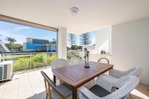 a dining room with a table and chairs at Dwell Apartment 33 in Bargara