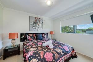a bedroom with a bed and a zebra picture on the wall at Dwell Apartment 33 in Bargara +24 photos