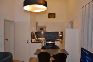 a kitchen with a table and chairs in a room at Aparthotel Sebastian in Erding