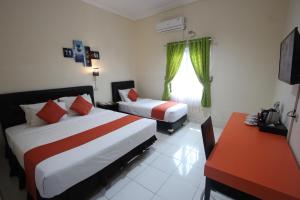a hotel room with two beds and a window at Yasminstar Hotel in Muntok +26 photos