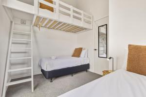 a bedroom with two beds and a bunk bed at Roam Taupo Lakefront Combined Units 3&4 in Taupo