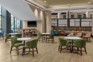 a waiting room with tables and green chairs at Embassy Suites San Antonio Riverwalk-Downtown in San Antonio