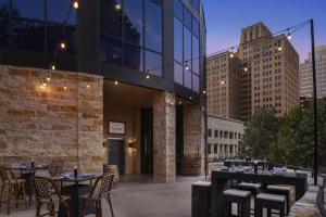 a patio with tables and chairs and a building at Embassy Suites San Antonio Riverwalk-Downtown in San Antonio