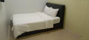 a bed with white sheets and pillows in a room at Elite Hotel in Kuantan