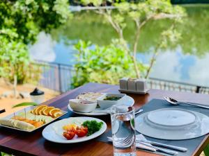 a wooden table with plates of food on it at Aqualuna Weligama in Weligama