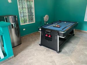 a ping pong table in a room with a pool table at Blue Paradise in Coxen Hole