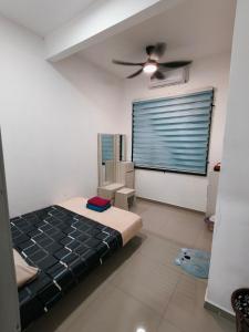 a bedroom with a bed and a ceiling fan at Atabara ECRL Stay Homestay in Kuantan