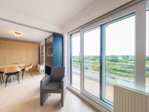 a room with large windows and a table and chairs at Rubens - 0505 in Middelkerke
