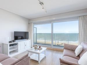 a living room with a view of the ocean at Romanza - 0405 + park.38 in Middelkerke