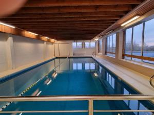 a large indoor swimming pool with blue water at Romanza - 0405 + park.38 in Middelkerke