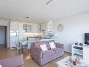 a living room and kitchen with a couch and a table at Romanza - 0405 + park.38 in Middelkerke +7 photos