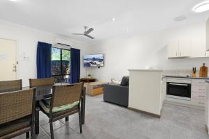 a kitchen and living room with a table and chairs at Sunset Escape in Broome