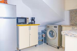 a kitchen with a microwave and a washer and dryer at perle de dakhla in Dakhla