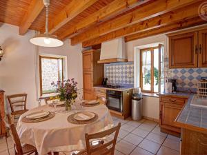a kitchen with a table and chairs and a kitchen with wooden cabinets at Gîte 4 pers avec jardin privé et animaux admis - FR-1-496-66 in Les Salles