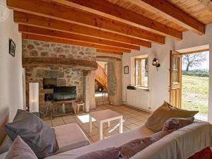 a living room with a couch and a stone fireplace at Gîte 4 pers avec jardin privé et animaux admis - FR-1-496-66 in Les Salles