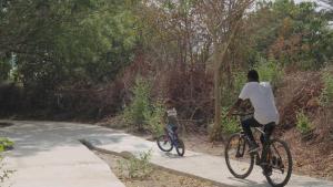 a man and a child riding bikes on a path at Suñu Tool Private Farm Guesthouse in Sindia
