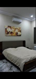 a bedroom with a bed and a painting on the wall at Le mirage in Tozeur